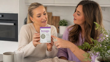 Two adult women holding and reviewing Elexir Borago Skin and Hormones