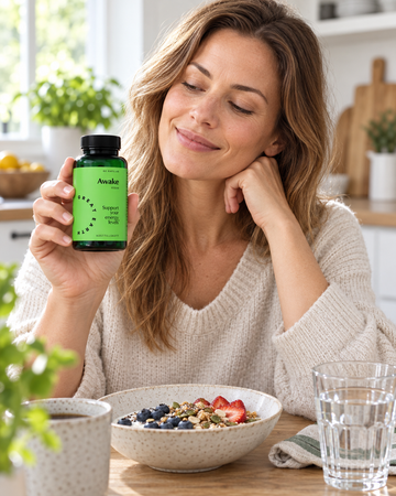 Woman holding Great Earth Awake 60 Capsules beside breakfast and water